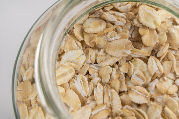 Oatmeal groats close-up in a jar on the background