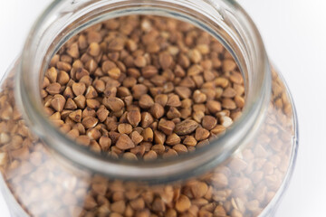 Buckwheat groats close-up in a bank on a background