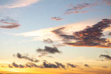 Dramatic sunset sky with orange clouds. Golden clouds in the sky.