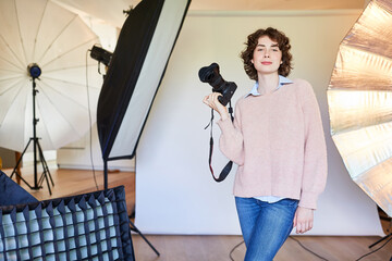 Selbstbewusste Fotografin mit Kamera im Fotostudio
