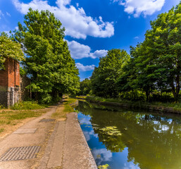 Fototapeta premium A view towards a narrow section of the Birmingham Canal at Tipton in summertime