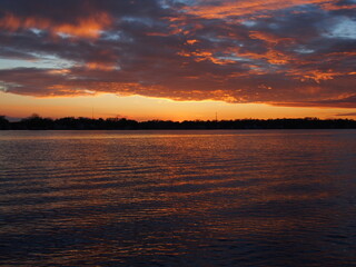 Michigan boaters enjoying a peaceful sunset on Lake Lansing in Haslett, Mi