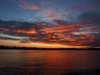 Michigan boaters enjoying a peaceful sunset on Lake Lansing in Haslett, Mi