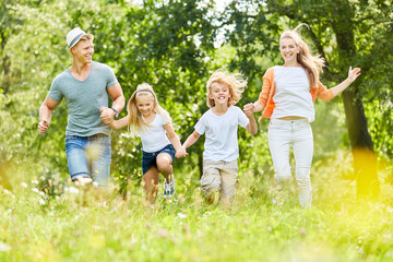 Familie und Kinder laufen über eine Wiese