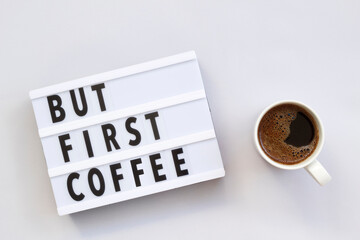 But First Coffee displayed on a vintage lightbox with coffee cup, concept image