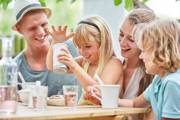 Blondes Mädchen spielt mit dem Zuckerstreuer