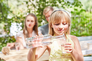 Mädchen gießt sich frisches Wasser ein