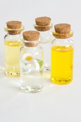 Beautiful photo of small bottles with cork stoppers filled with fantastic fragrant oils, essential oils, rose water and daisies