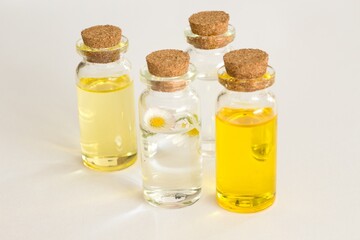 Beautiful photo of small bottles with cork stoppers filled with fantastic fragrant oils, essential oils, rose water and daisies