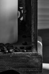 coffee beans trickling out of a wooden lantern, black and white