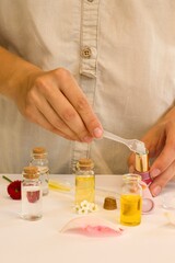 Beautiful and useful photo of a woman who makes homemade natural cosmetics and lipsticks from oils, essential oils, peppermint, rose water and aloe vera gel