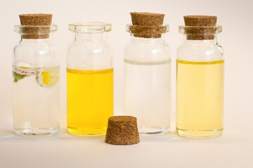 Beautiful photo of small bottles with cork stoppers filled with fantastic fragrant oils, essential oils, rose water and daisies