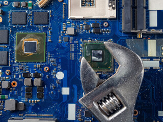 Computer repair concept, wrench on motherboard close up