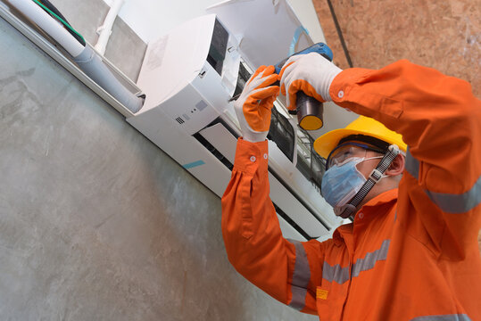 Mechanic Wearing Mask To Prevent Disease, Covid 19 Currently Using Electric Drill To Install Air Conditioner