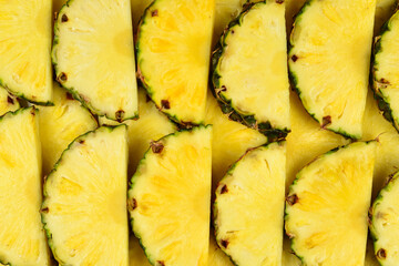 Pineapple juicy yellow slices background. Top view.