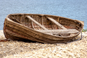 Wooden boat on cobblestone beach