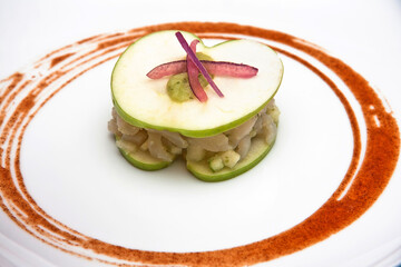 Plato de Ceviche de pescado con tapas de manzana, salsa picante y cebolla morada, vista de cerca
