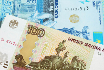 A macro image of a Russian one hundred ruble note paired up with a blue, plastic five hunded tenge bank note from Kazakstan.  Shot close up in macro.