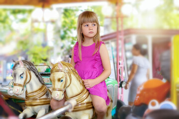 Beautiful little girl on a retro carousel ride