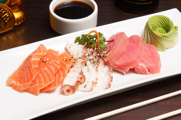 Sashimi de pulpo y camarón con soya y palillos.