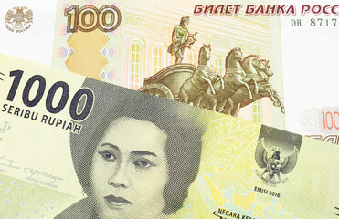 A macro image of a Russian one hundred ruble note paired up with a green one thousand bank note from Indonesia.  Shot close up in macro.