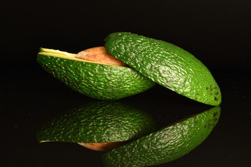 Green fresh ripe tasty avocado, close-up, on a black background.
