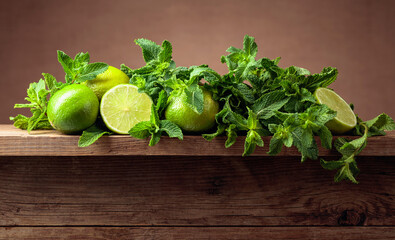 Fresh green mint and limes on a old wooden table.