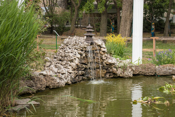 Stone waterfall on the background of columns above the pond