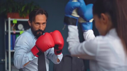 Business people vie boxing on gloves. A man and a woman in business clothes are trying hard to determine which one is stronger. Gender Conflict Concept. Prores 422.  - Powered by Adobe