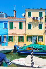 Boats and colorful houses by canal in Burano in Venice