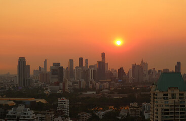 Fototapeta na wymiar Stunning view of the bright sun setting over the city