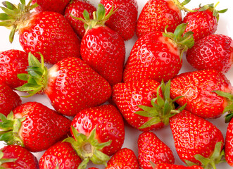 Ripe strawberries in the center of a white plate, on a white background