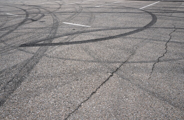 Asphalt texture with white line and tire marks.  Smooth asphalt road. Tarmac dark grey grainy road background.Top view