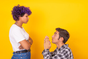 young man and woman couple asking for forgiveness isolated on background