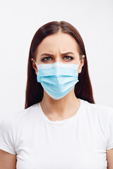 Brunette woman wearing disposable mask shows emotions with her eyes