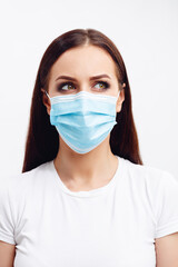 Brunette woman wearing disposable mask shows emotions with her eyes