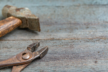 Carpenters tools on a wooden table. Hammer and pliers on table. Copy space.