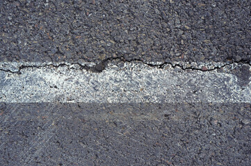 Asphalt texture with white line and tire marks.  Smooth asphalt road. Tarmac dark grey grainy road background.Top view