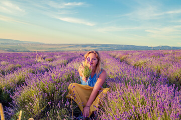 Girl in a lavender field at sunset. Sunny summer evening in Crimea.