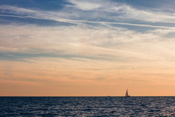A beautiful sky with a boat in the sea with clouds over