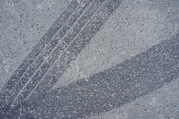 Naklejka premium Asphalt texture with white line and tire marks. Smooth asphalt road. Tarmac dark grey grainy road background.Top view