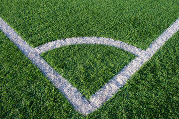 Green grass and white border lines on football ground. Soccer field on artificial turf. Artificial...