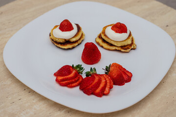 Delicious homemade pancakes with strawberries on plate on a light background