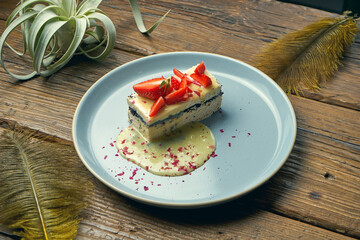 Healthy dessert - cottage cheese casserole with poppy seeds and strawberries in a plate on a wooden background