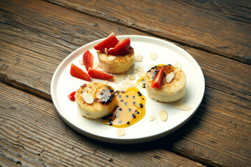 Vegetarian Tofu Cheesecakes with Almonds, Strawberries and Passion Fruit Jam on wooden background
