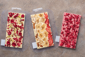 Handmade chocolate bars with freeze dried berries and walnut in molds.