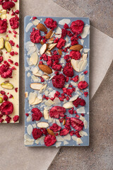 Craft white chocolate with freeze-dried raspberries and almond. Flat lay.