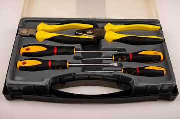 Various screwdrivers and pliers in a plastic case. Close up. Manual locksmith and installation tools for home work.