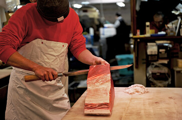 Tsukiji, Tokyo, Japan - March 25, 2015 : One of the most famous seafood market in the world, Bursting chefs in action as they fillet the fish.