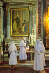 ROME, ITALY - 2014 AUGUST 17. Nuns lights a candle in the Church in Rome.